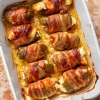 Baked jalapeño poppers sit in a white baking dish.
