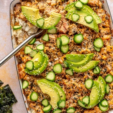 Avocado and cucumber slices top the sushi bake.