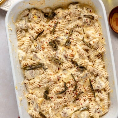 Butternut squash goat cheese pasta bake sits in a white casserole dish.