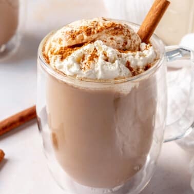 A cinnamon dolce latte topped with whipped cream and a cinnamon stick.