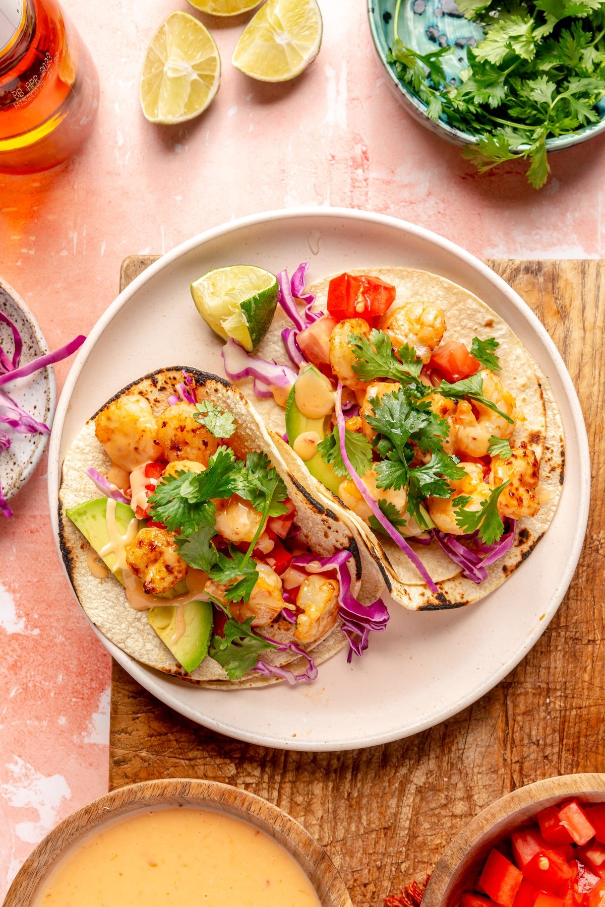 Spicy Bang Bang Shrimp Tacos sitting on a cream colored plate.