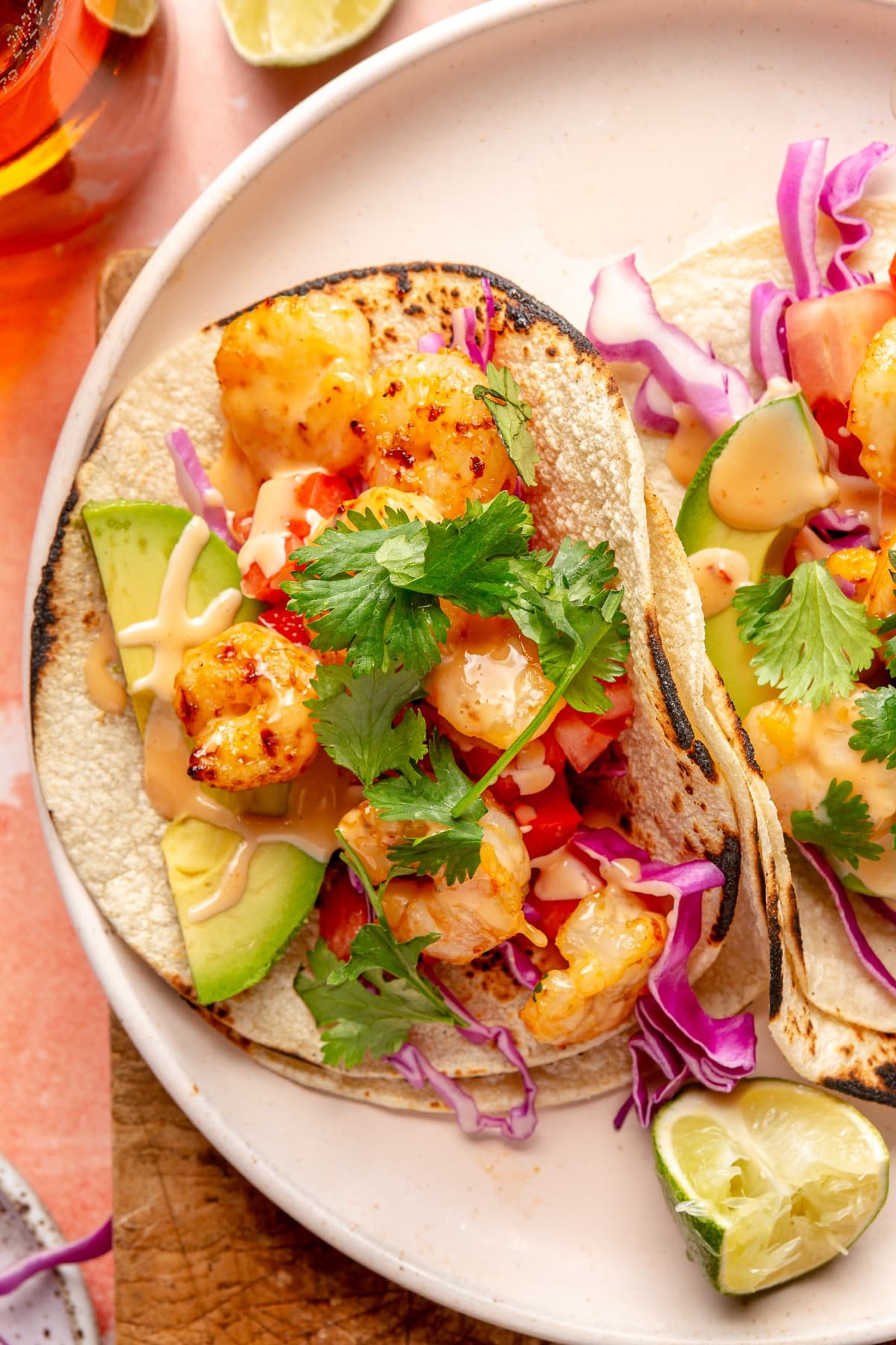 Spicy Bang Bang Shrimp Tacos sitting on a cream colored plate.