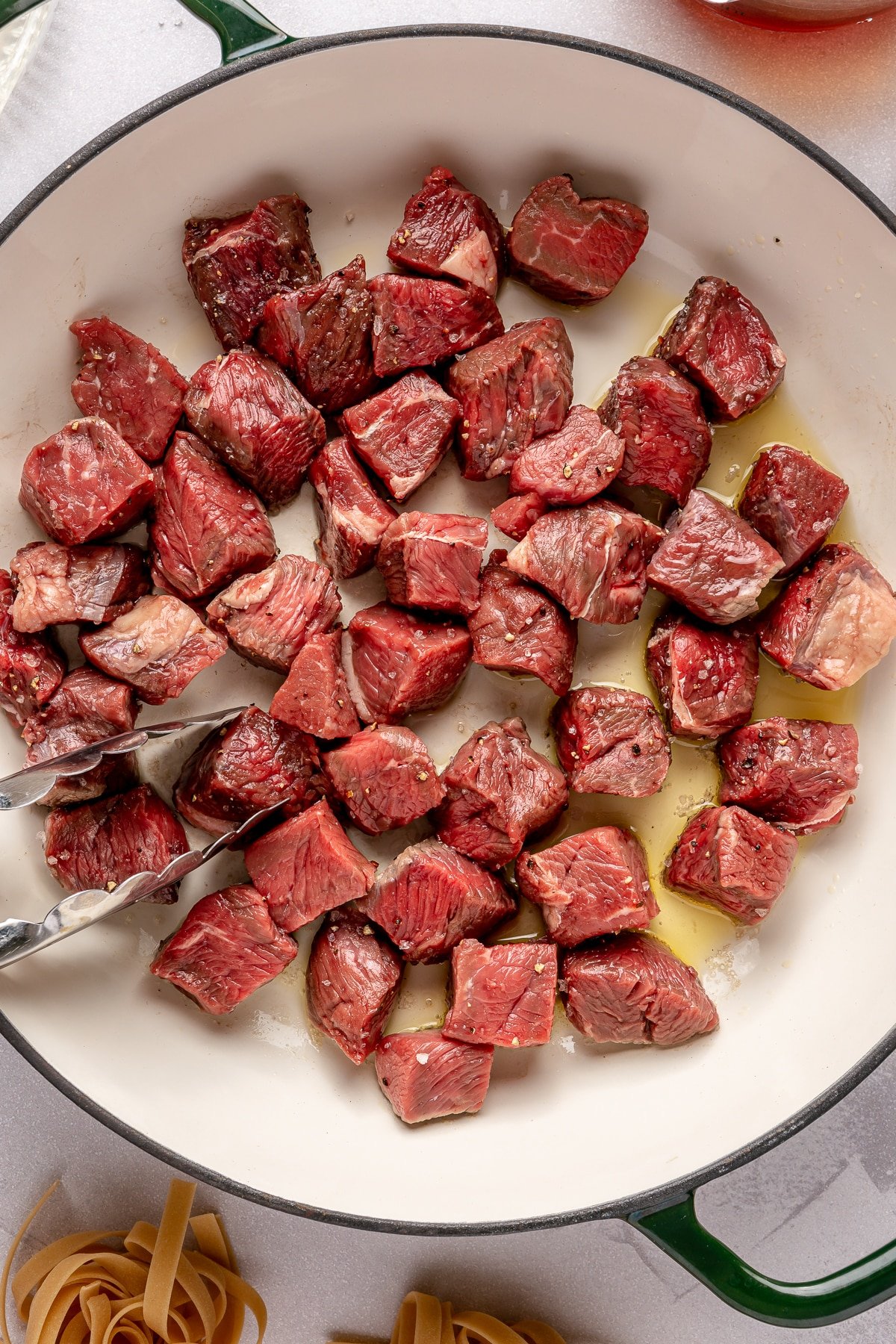 Steak tips searing on a hot pan.