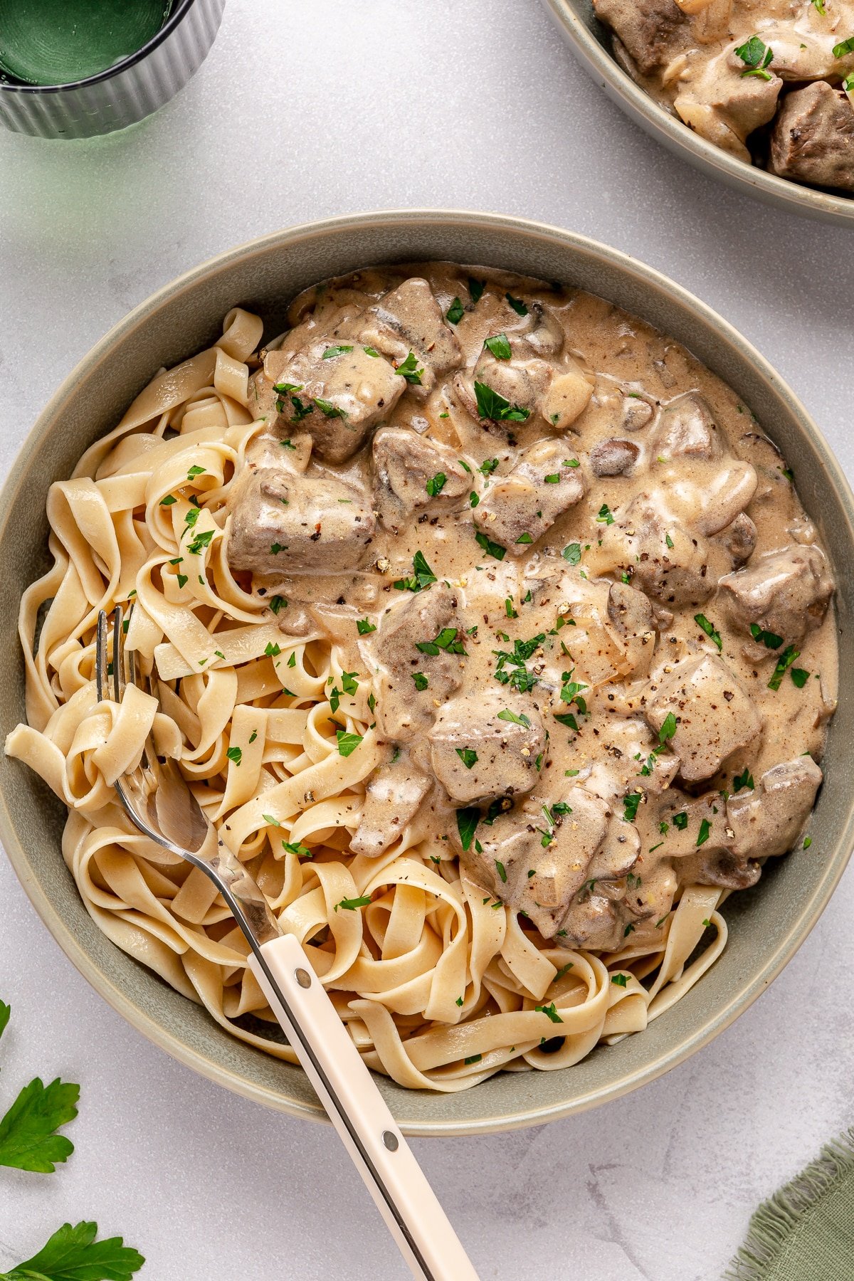 Beef stroganoff served on a plate with pasta.