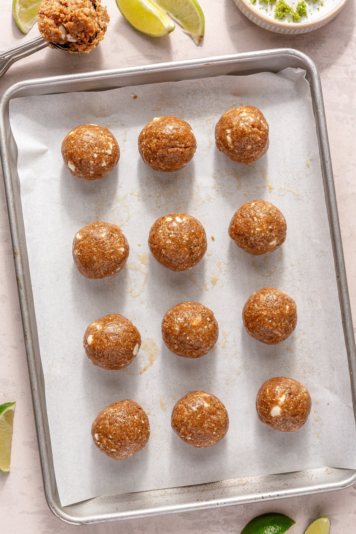 Key Lime Pie energy balls on a parchment paper lined baking sheet.