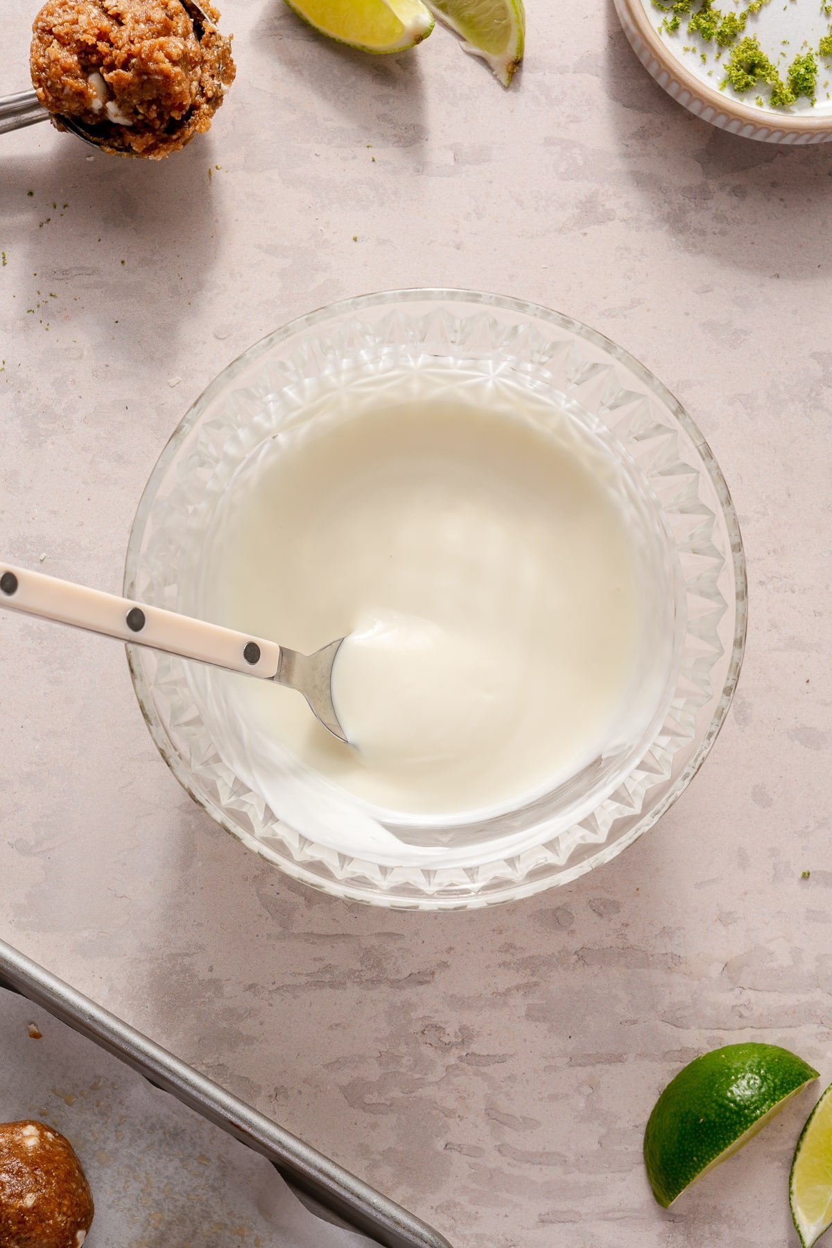 Melted white chocolate in a small glass bowl.