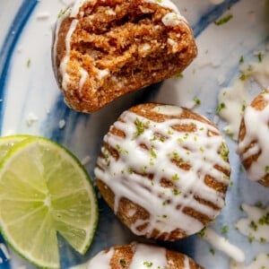 Key Lime Pie energy balls sitting on a blue and white plate next to a cut lime.