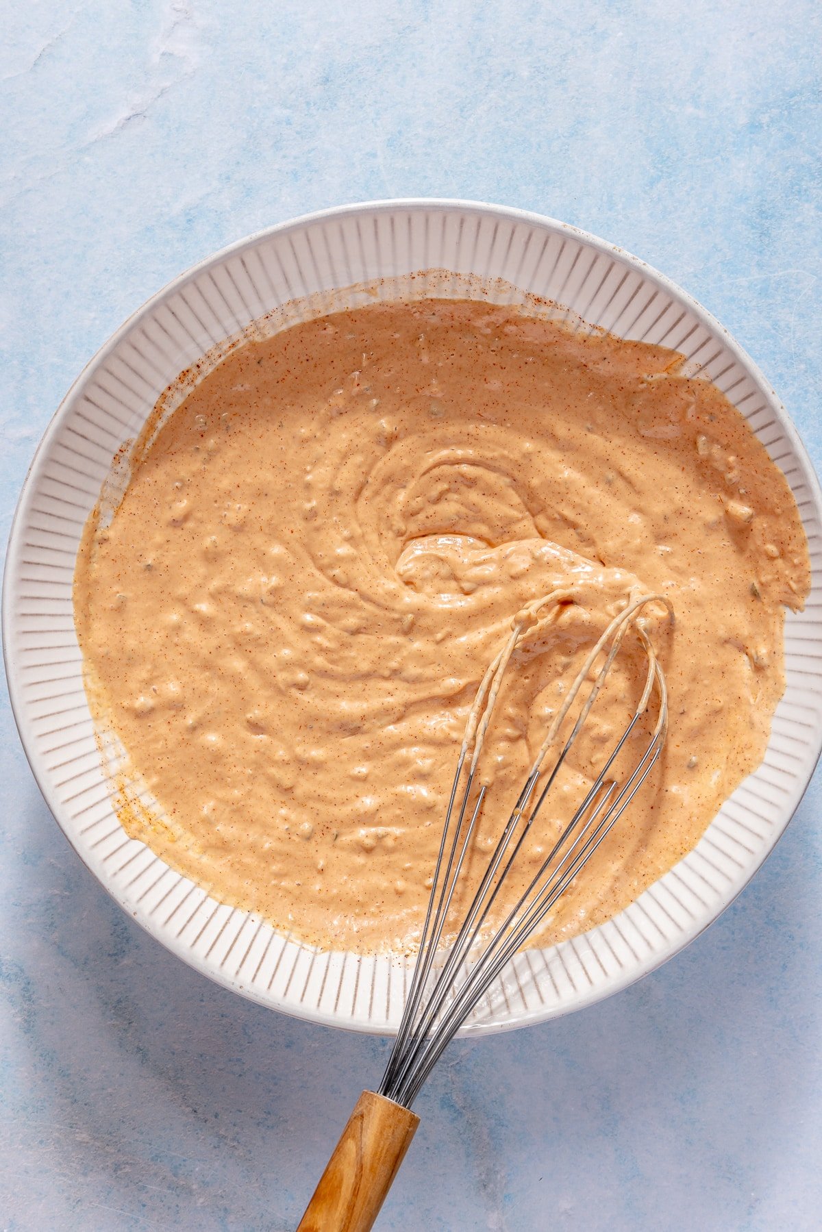 Burger sauce being whisked together in a white bowl.