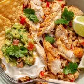 Finished Instant Pot chicken fajitas served with tortilla chips, sour cream, cilantro, and fresh lime.