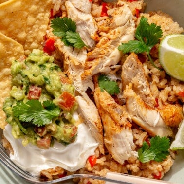 Finished Instant Pot chicken fajitas served with tortilla chips, sour cream, cilantro, and fresh lime.