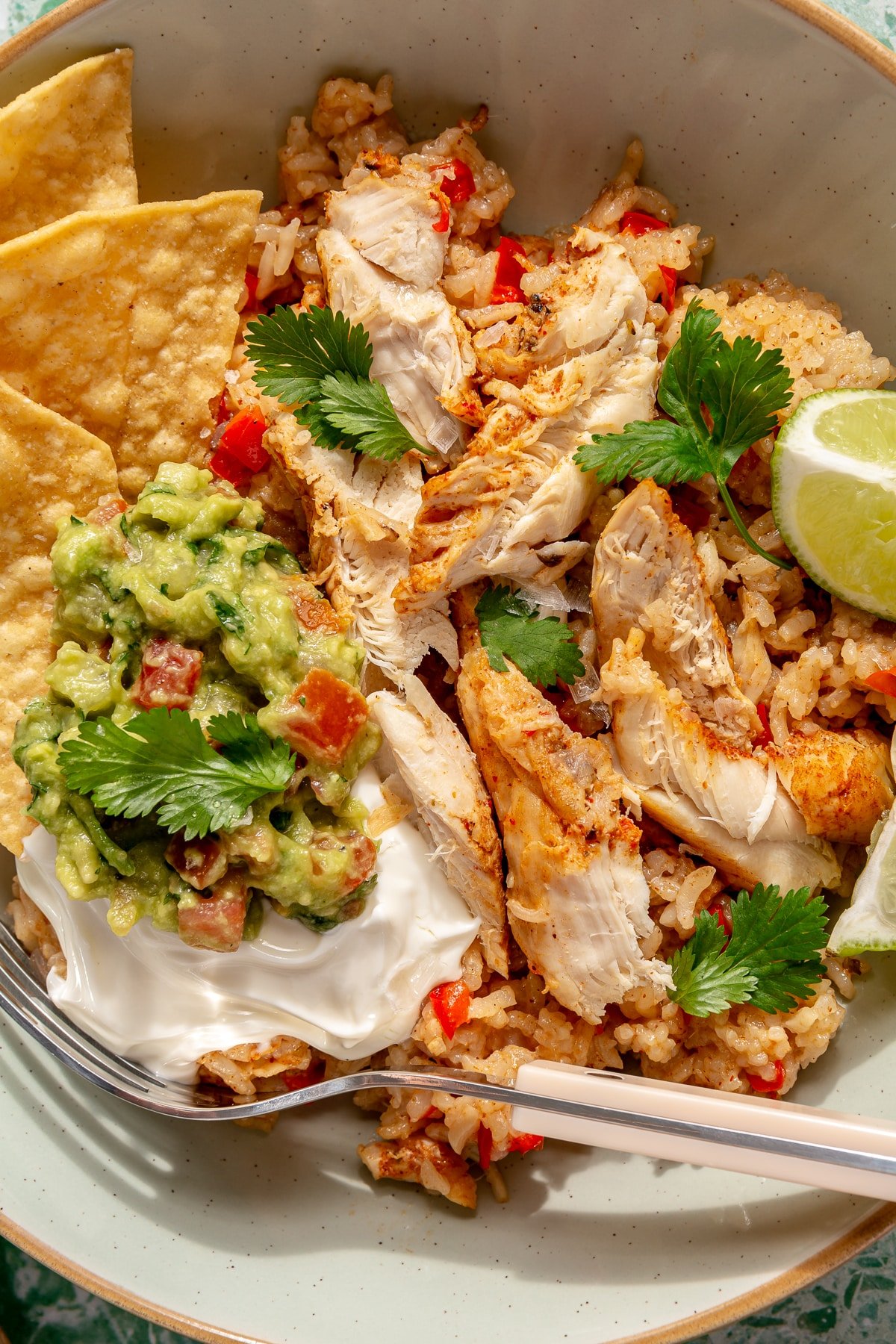 Finished Instant Pot chicken fajitas served with tortilla chips, sour cream, cilantro, and fresh lime.