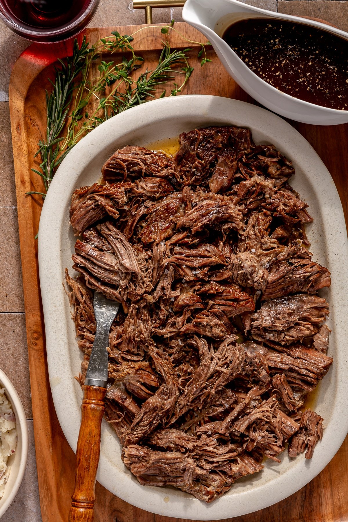 A large off white platter of shredded pot roast.