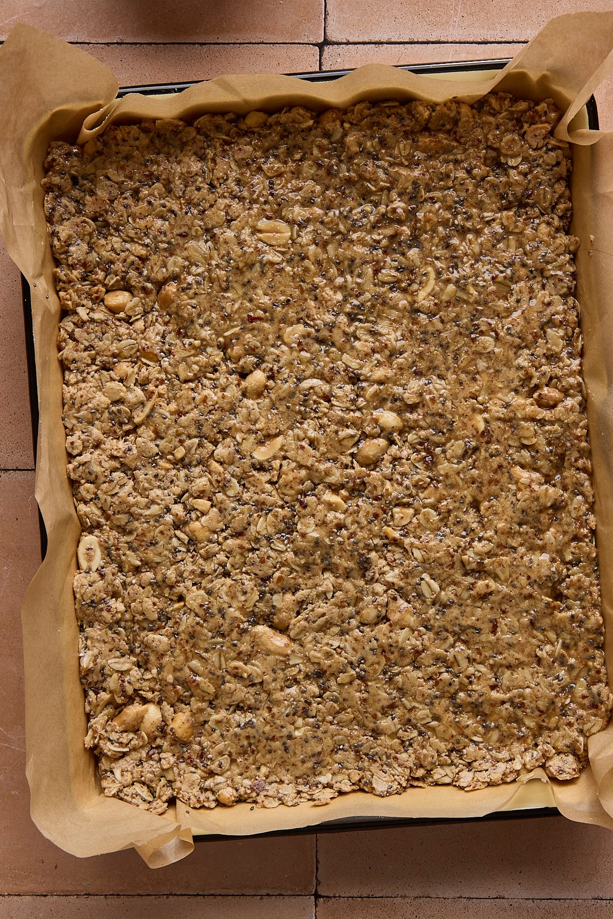 High protein and fiber bars pressed into a baking sheet before being sliced into squares.