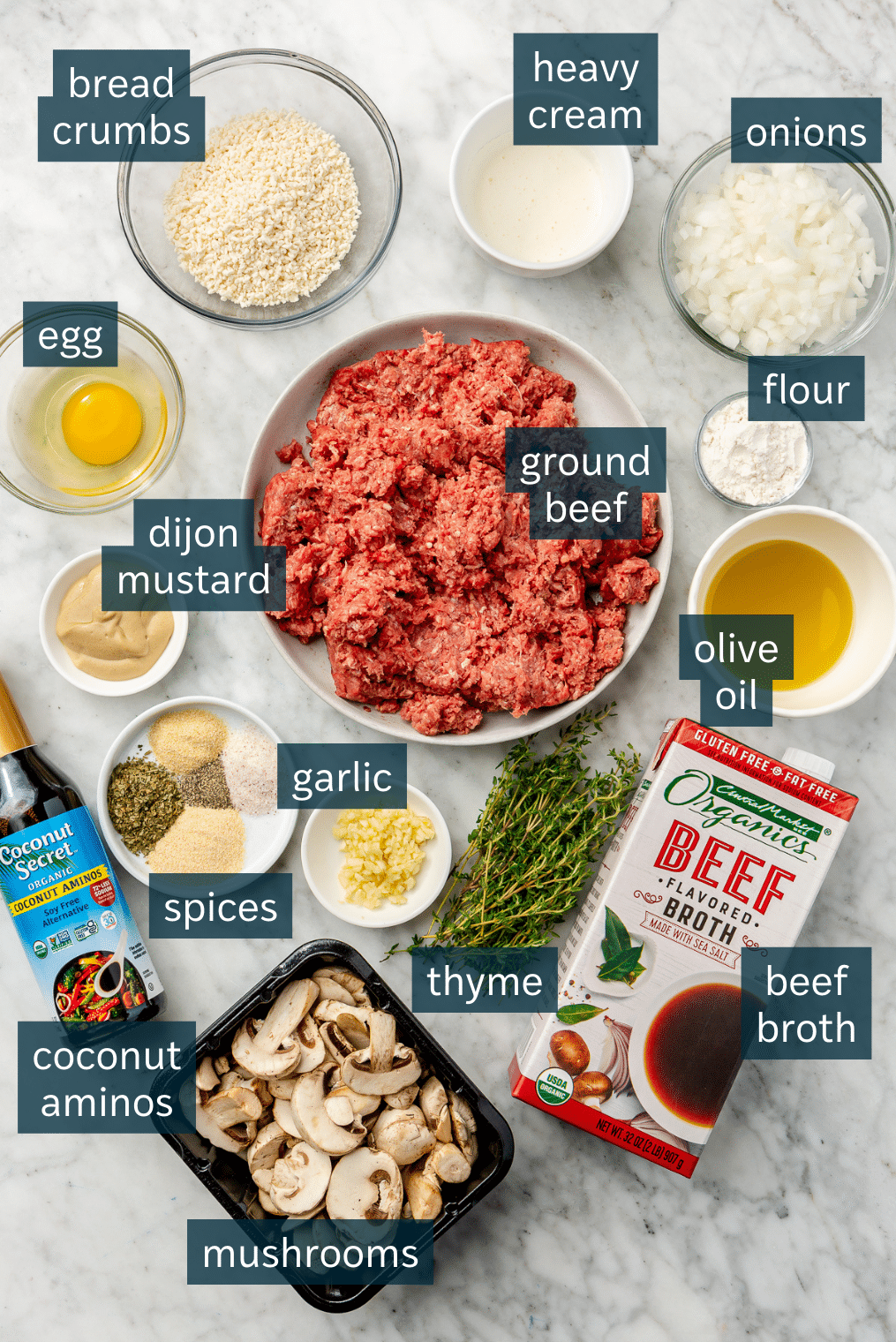 All of the ingredients needed for salisbury steak measured out on a marble surface.