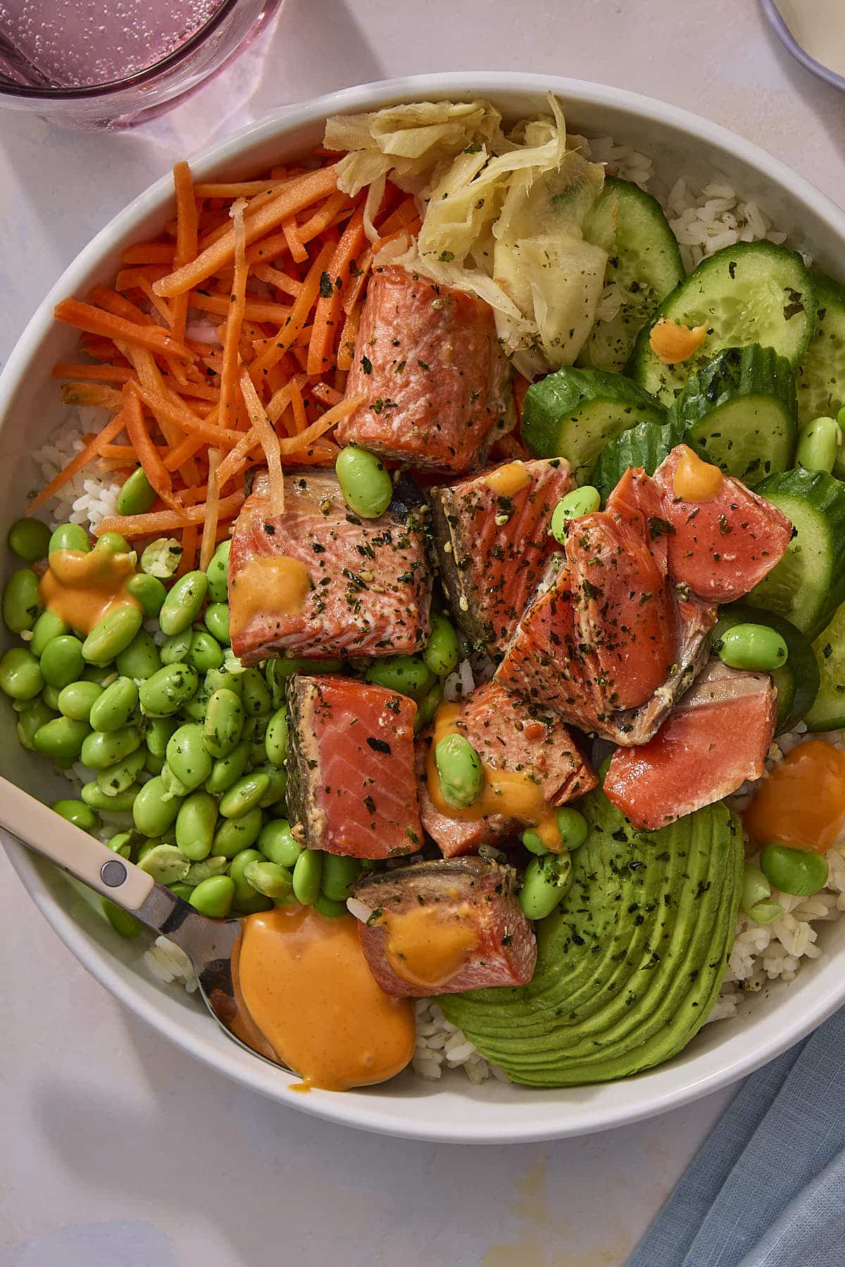 Finished and assembled poke bowls topped with spicy mayonnaise.