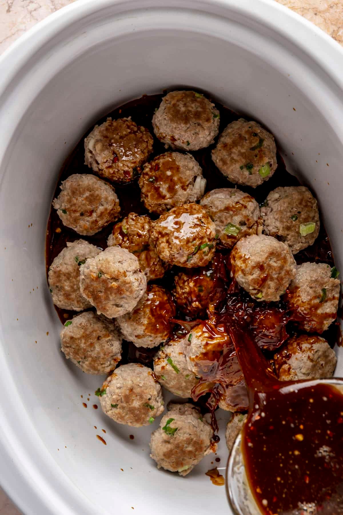 A slow cooker basin of turkey teriyaki meatballs.