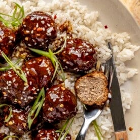 Turkey teriyaki meatballs on a bed of rice in a bowl.