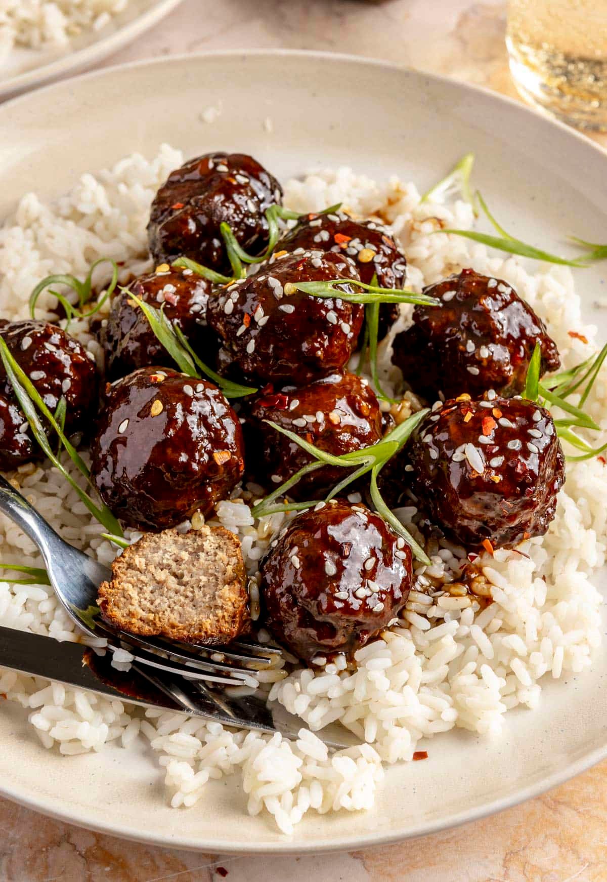Turkey teriyaki meatballs on a bed of rice in a bowl.