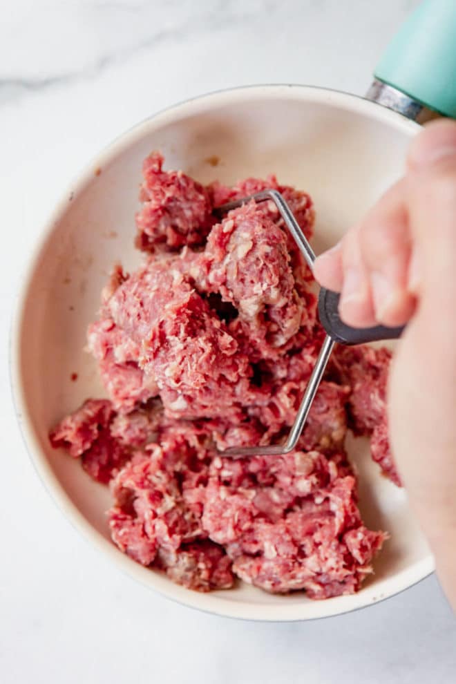 Use Your Potato Masher To Break Up Ground Meat in the Skillet