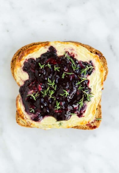 Blackberry thyme yogurt toast on a gray and white marble background.