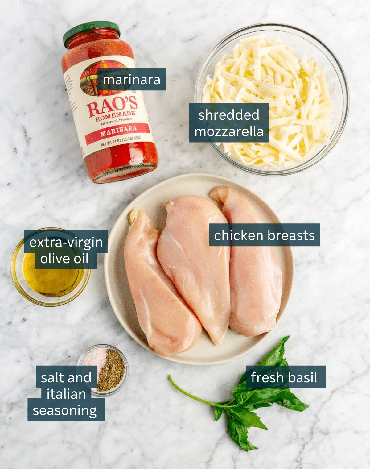 Ingredients for easy baked chicken marinara sit on a marble counter.