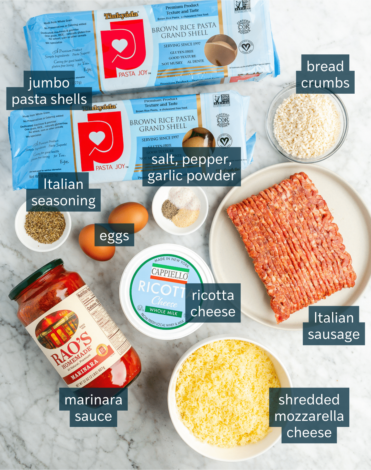 All of the ingredients needed for stuffed pasta shells on a marble surface.