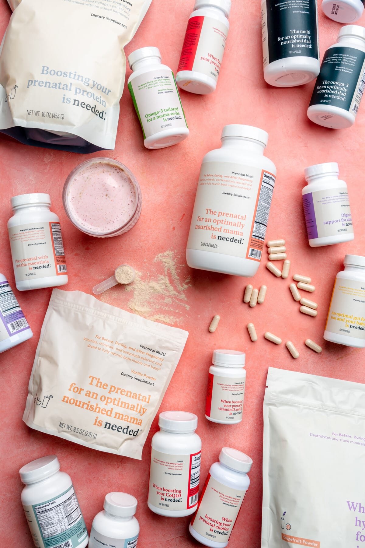 A bunch of Needed supplement products laying on a pink surface.