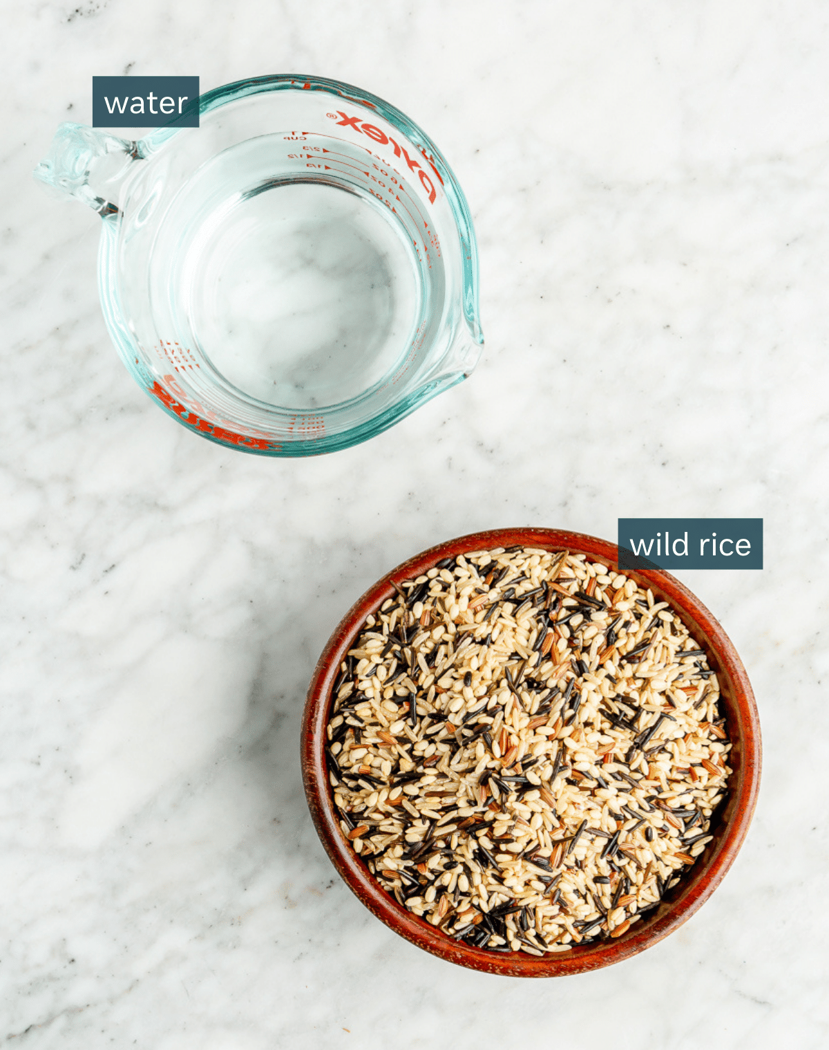 Ingredients needed for perfect wild rice sitting on a marble countertop.