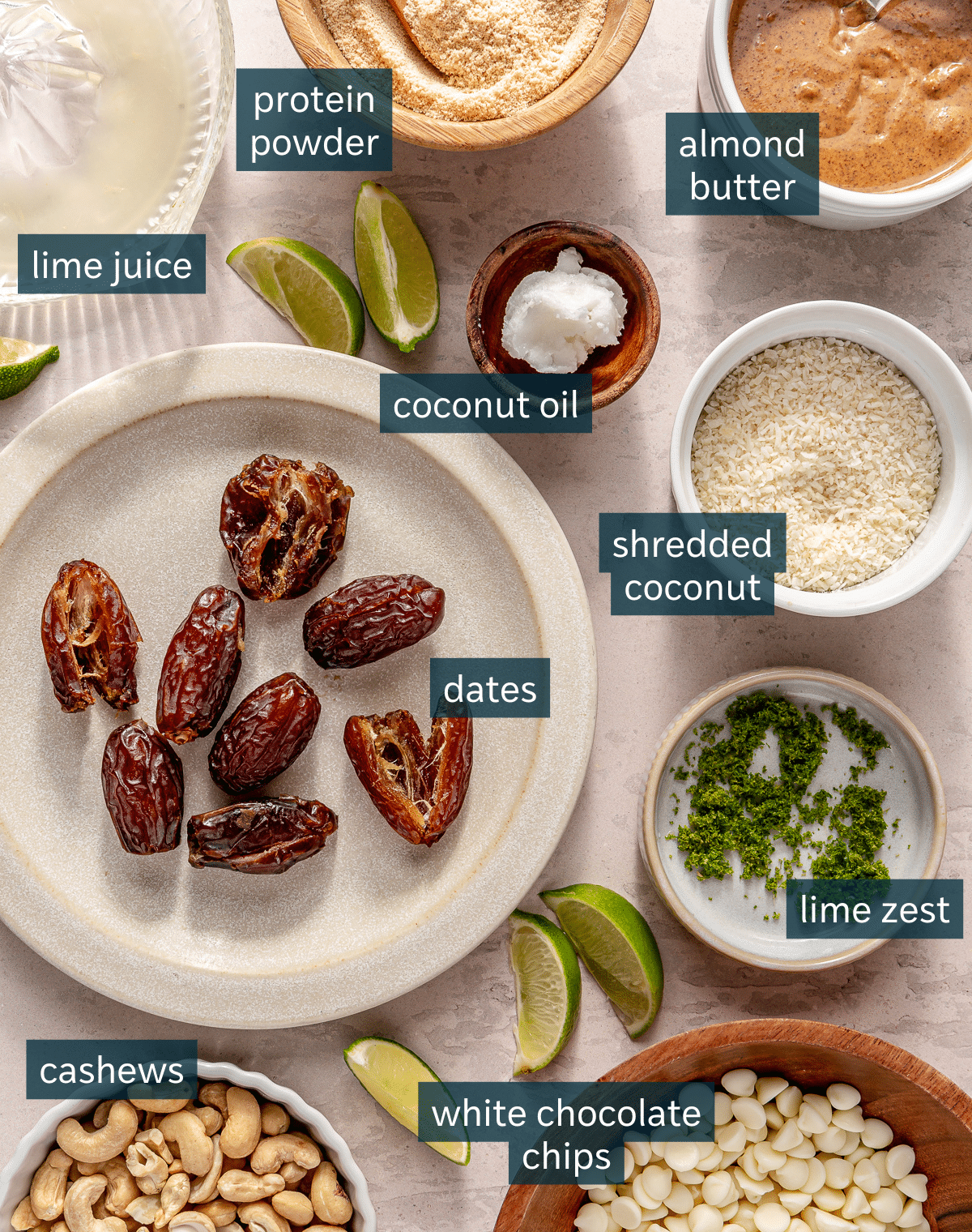 All of the ingredients needed for Key Lime Pie energy balls in small bowls on a light surface.