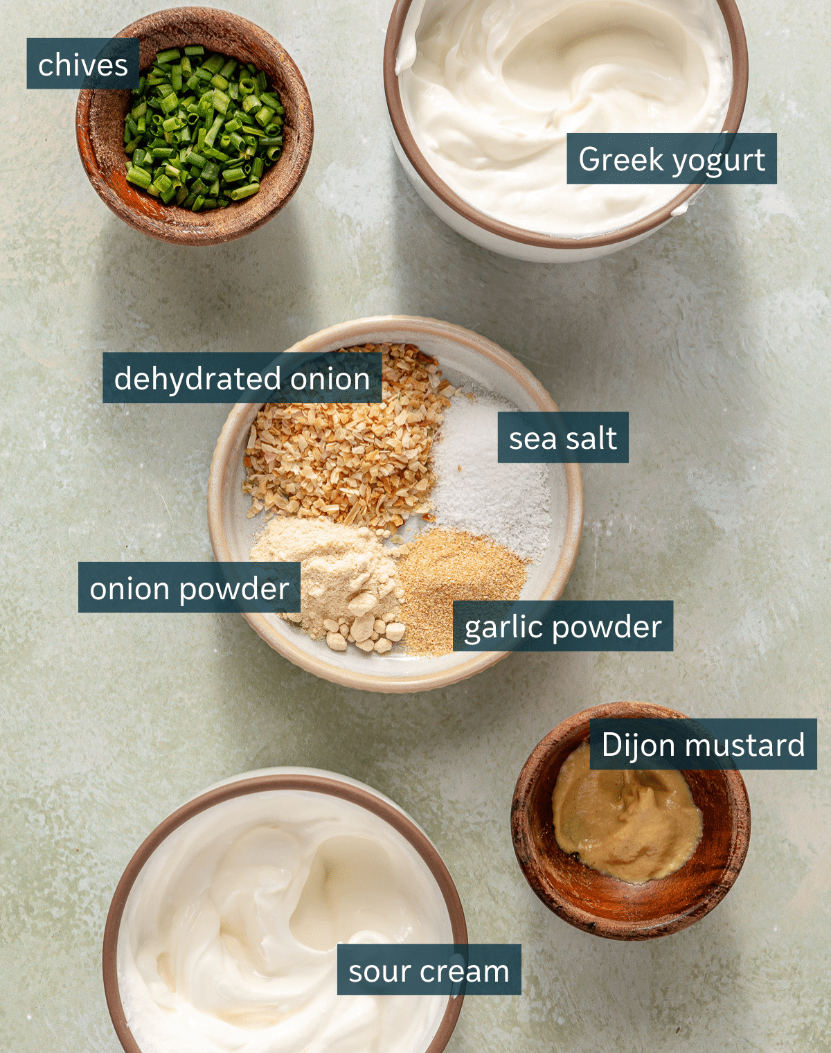 All of the ingredients needed to make fresh homemade French Onion dip measured and stored in different sized bowls.